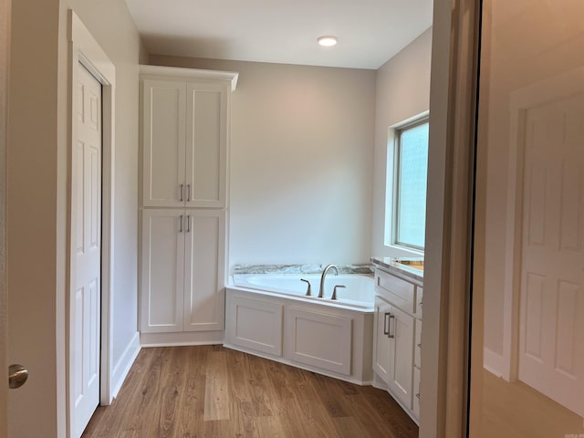 bathroom with a bath, wood-type flooring, and vanity