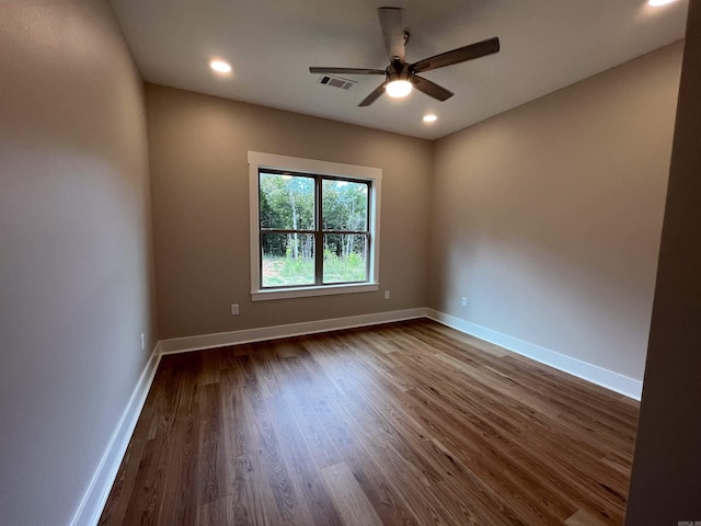 spare room with ceiling fan and dark wood-type flooring