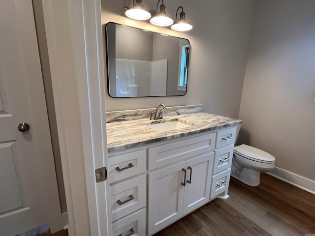 bathroom featuring vanity, hardwood / wood-style floors, and toilet