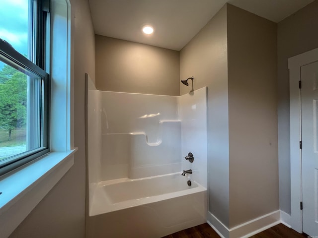 bathroom with wood-type flooring and  shower combination