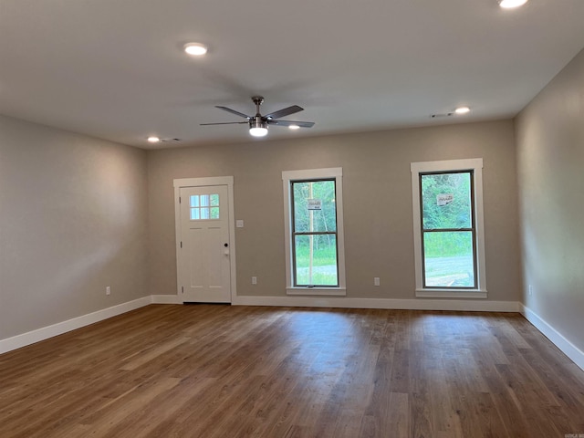 empty room with ceiling fan and dark hardwood / wood-style flooring