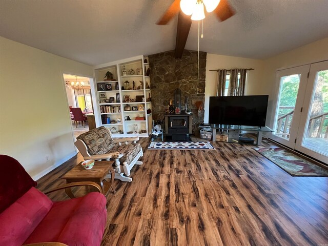 living room featuring ceiling fan, vaulted ceiling with beams, hardwood / wood-style floors, and a wood stove