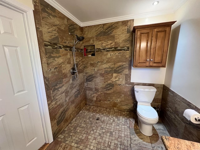 bathroom featuring ornamental molding, tile walls, toilet, and tiled shower