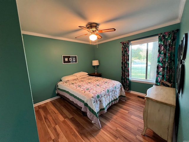 bedroom featuring wood-type flooring, ornamental molding, and ceiling fan