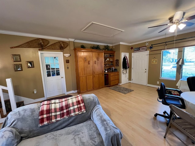 interior space with ornamental molding, light wood-type flooring, and ceiling fan