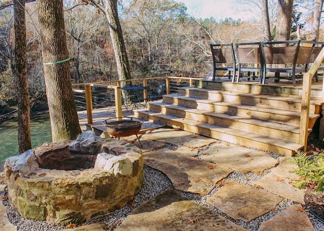 view of patio / terrace with an outdoor fire pit and a deck with water view