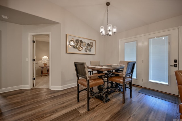 dining space with an inviting chandelier, vaulted ceiling, and dark wood-type flooring