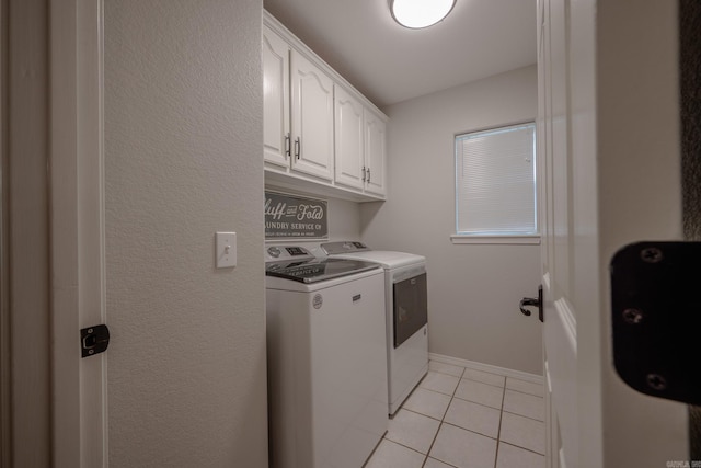 laundry area with light tile patterned floors, independent washer and dryer, and cabinets