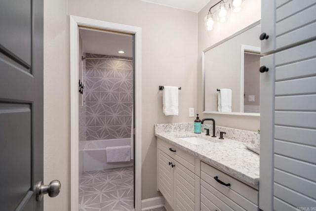 bathroom featuring tiled shower / bath, vanity, and tile patterned floors