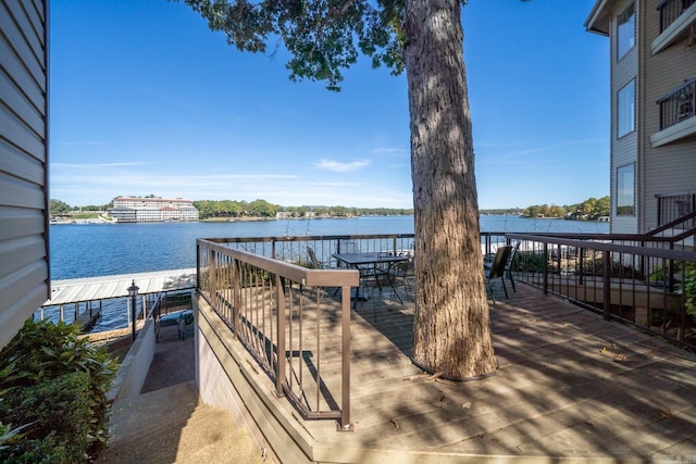 view of community with a deck with water view