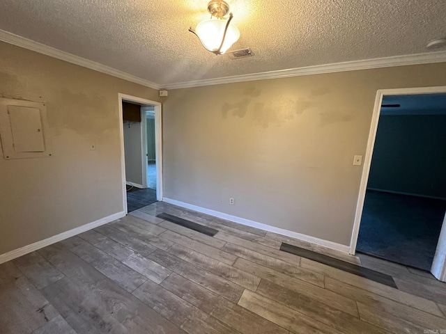 unfurnished room with a textured ceiling, ornamental molding, hardwood / wood-style floors, and electric panel