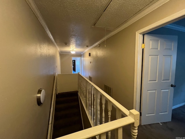 stairway featuring wood-type flooring, a textured ceiling, and ornamental molding