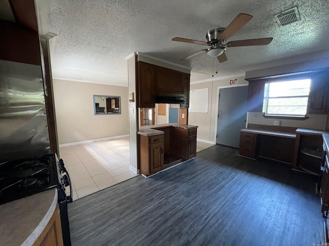 kitchen featuring ceiling fan, ornamental molding, black gas range, a textured ceiling, and light hardwood / wood-style floors