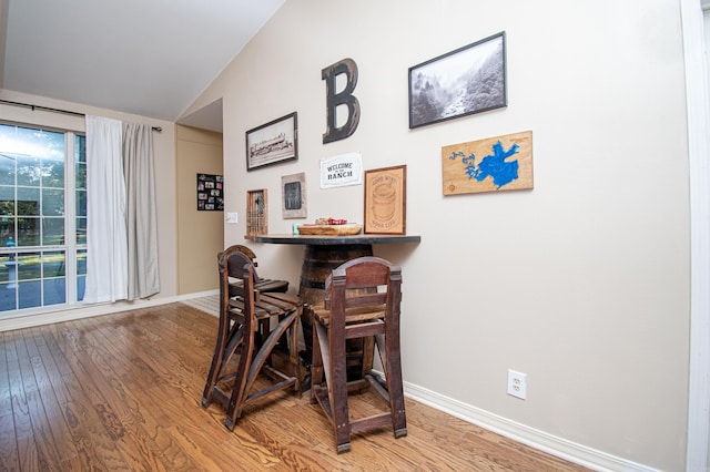 dining room with lofted ceiling and hardwood / wood-style floors