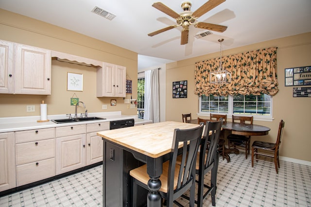 kitchen featuring black dishwasher, wood counters, sink, ceiling fan with notable chandelier, and hanging light fixtures