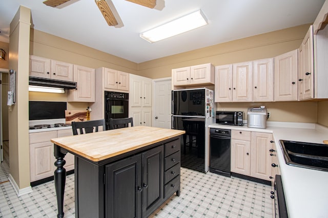 kitchen with black appliances, ceiling fan, and a kitchen island