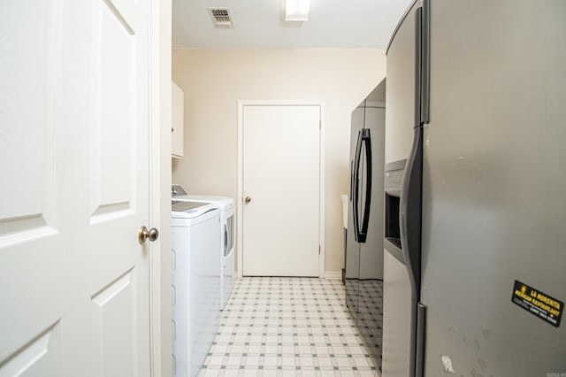 washroom with cabinets and washing machine and dryer