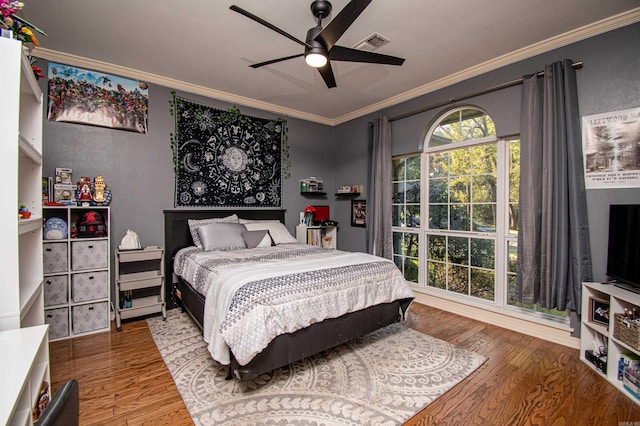 bedroom featuring ceiling fan, ornamental molding, and hardwood / wood-style floors