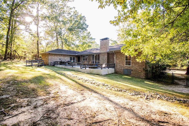 back of house featuring a lawn, cooling unit, and a deck