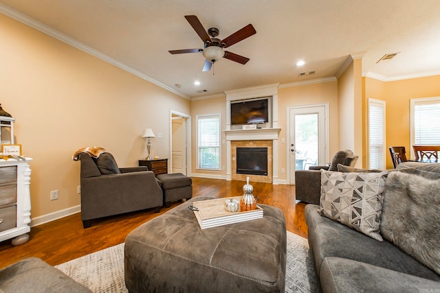 living room featuring crown molding, a fireplace, ceiling fan, and dark wood-type flooring