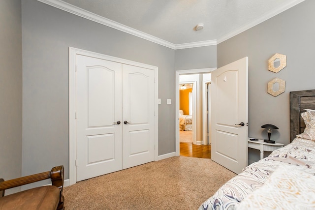 bedroom with a textured ceiling, ornamental molding, light colored carpet, and a closet