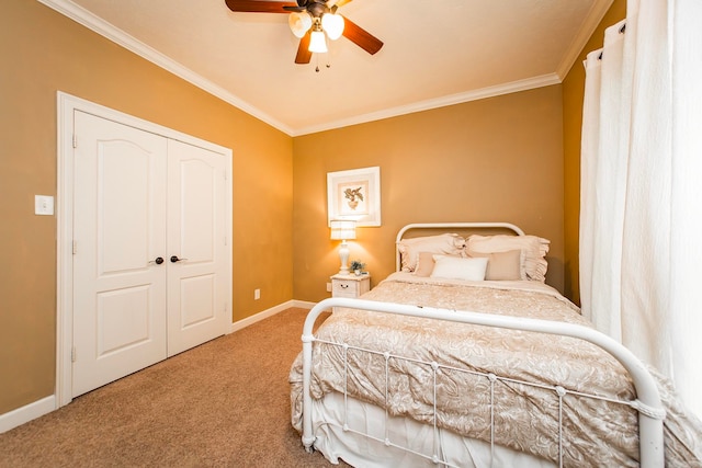 carpeted bedroom with ceiling fan, a closet, and crown molding