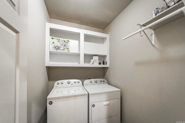 washroom with a textured ceiling and washer and clothes dryer