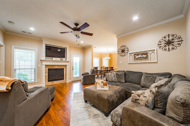 living room featuring ornamental molding, ceiling fan, a fireplace, and hardwood / wood-style floors