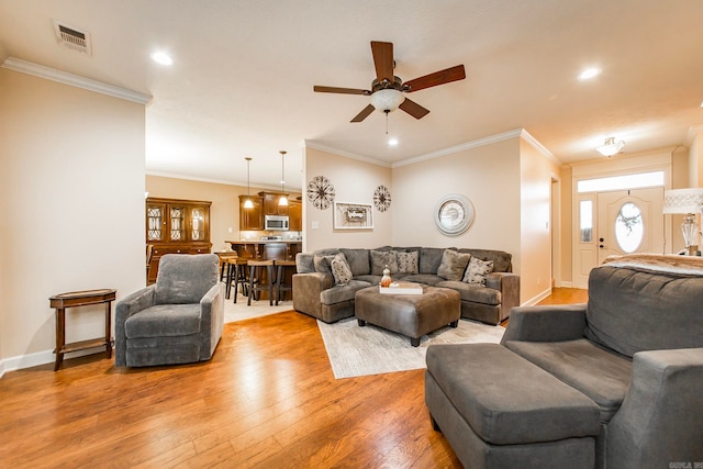 living room featuring ceiling fan, crown molding, and light hardwood / wood-style floors