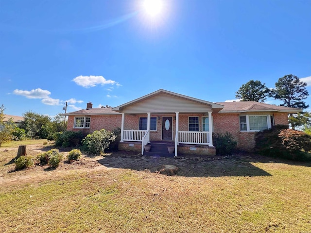 ranch-style house featuring a front lawn and covered porch