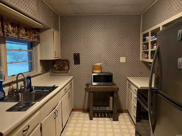 kitchen featuring refrigerator, black range with electric cooktop, and sink