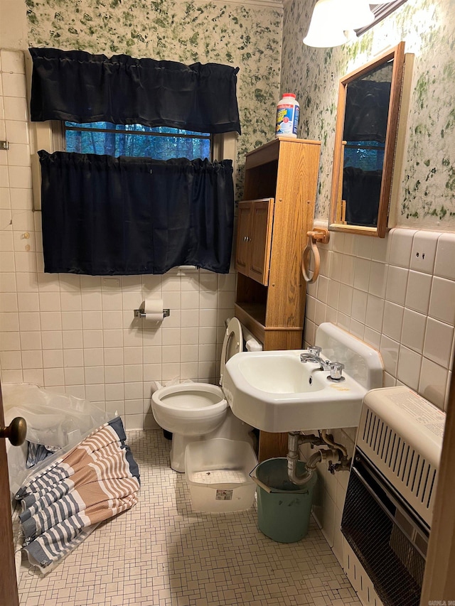 bathroom featuring tile walls, tile patterned flooring, heating unit, sink, and toilet