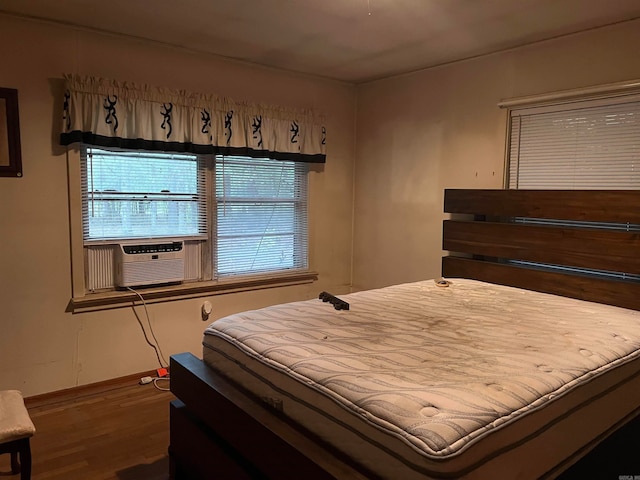 bedroom with cooling unit and dark hardwood / wood-style floors