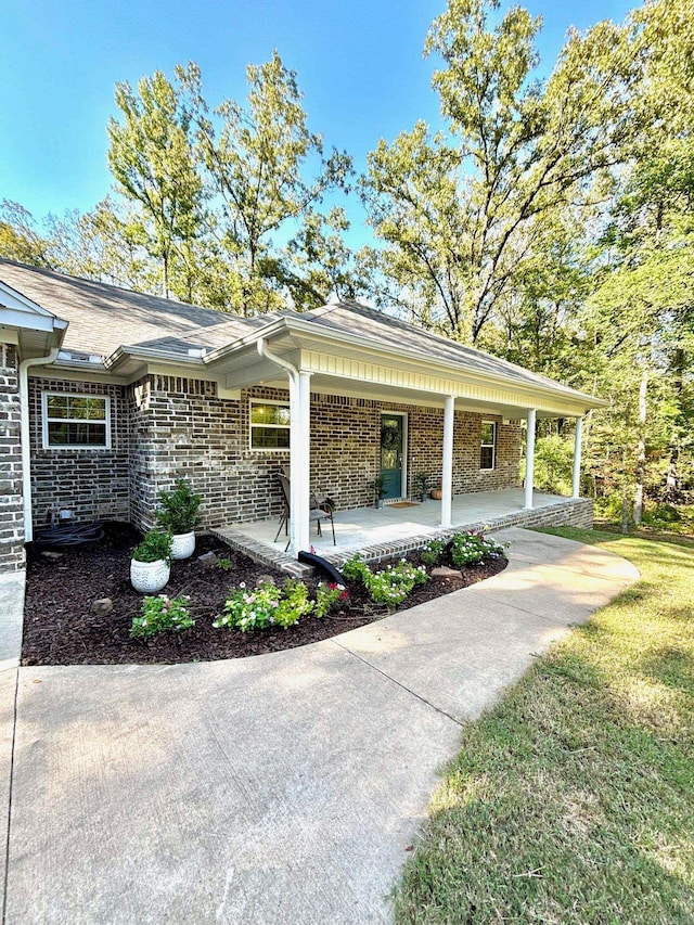 view of home's exterior with a lawn and covered porch