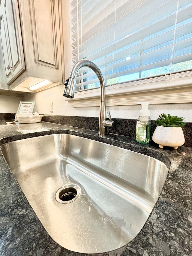 room details featuring dark stone counters and sink