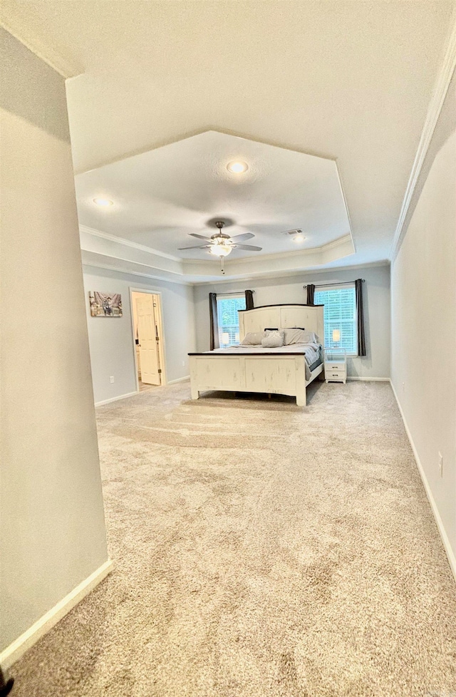 unfurnished living room with a textured ceiling, light carpet, a raised ceiling, ornamental molding, and ceiling fan