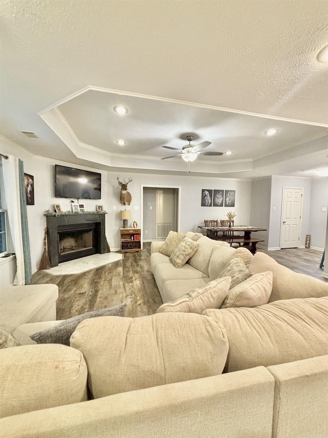 265 Pleasant Oaks Loop, El Paso, AR 72045 - living area featuring a tray ceiling, wood finished floors, a fireplace with raised hearth, and crown molding