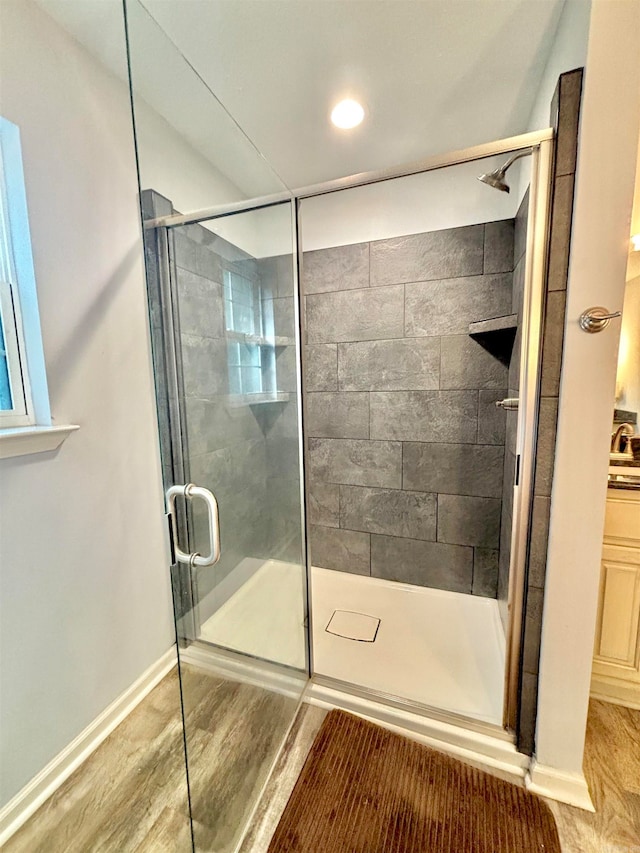 bathroom featuring wood-type flooring and a shower with door