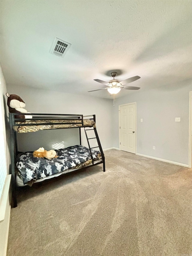 bedroom featuring a textured ceiling, carpet, and ceiling fan