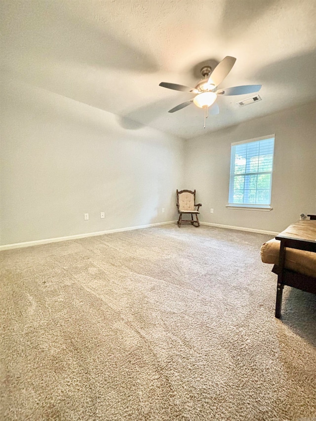 unfurnished room featuring a textured ceiling, carpet, and ceiling fan