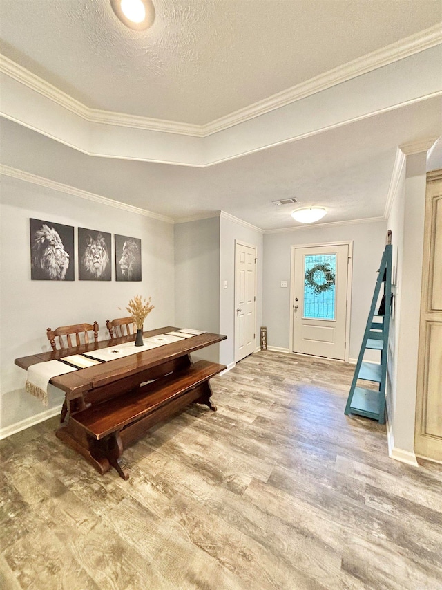 miscellaneous room featuring ornamental molding, wood-type flooring, and a textured ceiling