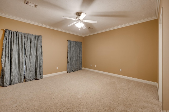 carpeted spare room with ceiling fan, a textured ceiling, and ornamental molding