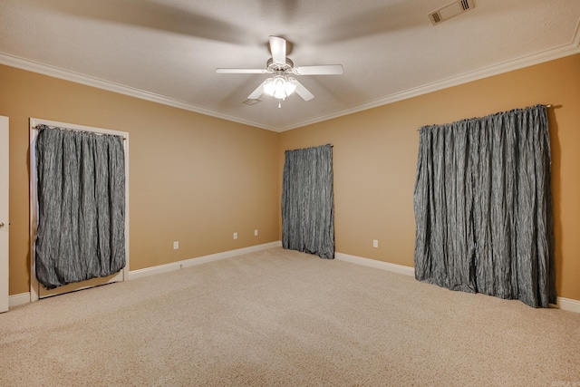 unfurnished room with ceiling fan, carpet flooring, and crown molding