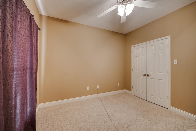 unfurnished bedroom with a closet, ceiling fan, carpet floors, and a textured ceiling