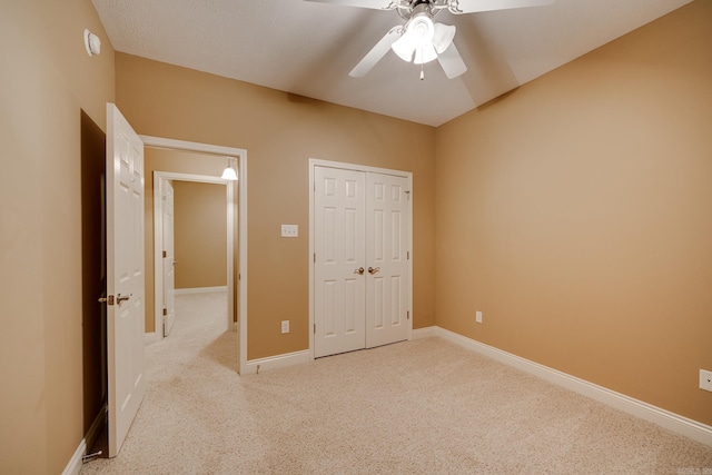 unfurnished bedroom with ceiling fan, light colored carpet, and a closet