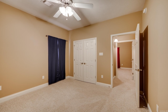 unfurnished bedroom with a closet, ceiling fan, and light colored carpet