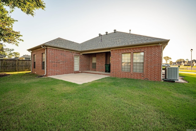 back of house with cooling unit, a lawn, and a patio area