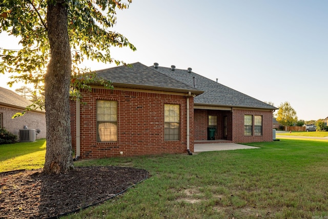 rear view of property with central AC unit, a patio area, and a yard