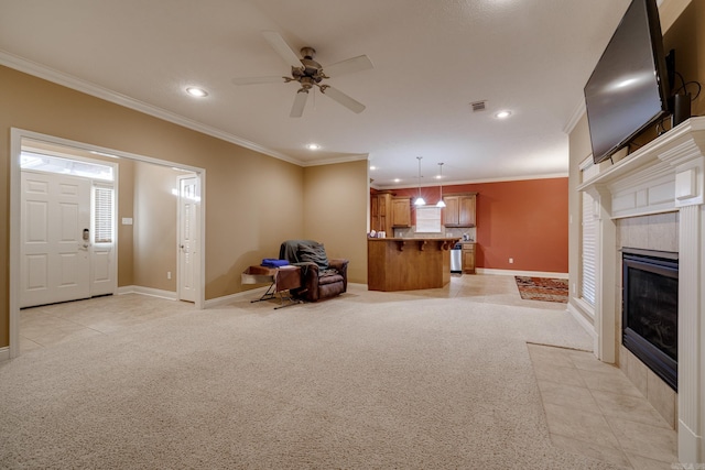 unfurnished living room featuring a fireplace, ornamental molding, ceiling fan, and light carpet