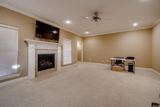 unfurnished living room with a tile fireplace, ornamental molding, ceiling fan, and light colored carpet